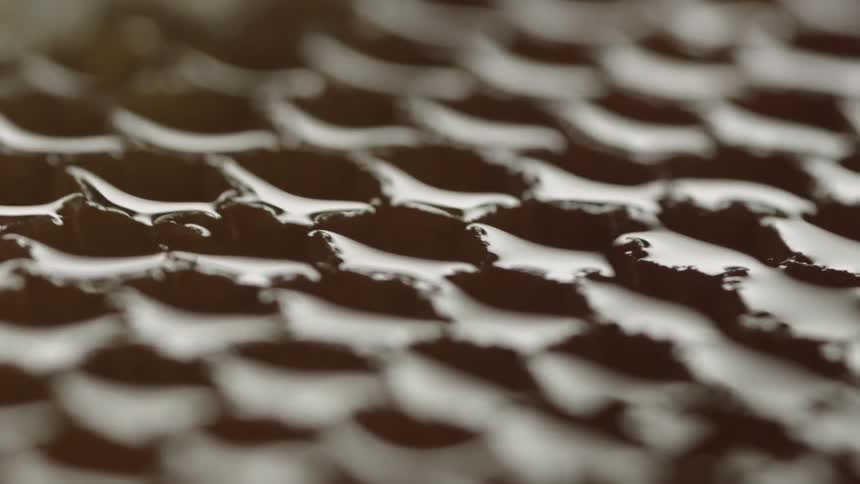 Light reflects off a honeycomb grate pattern