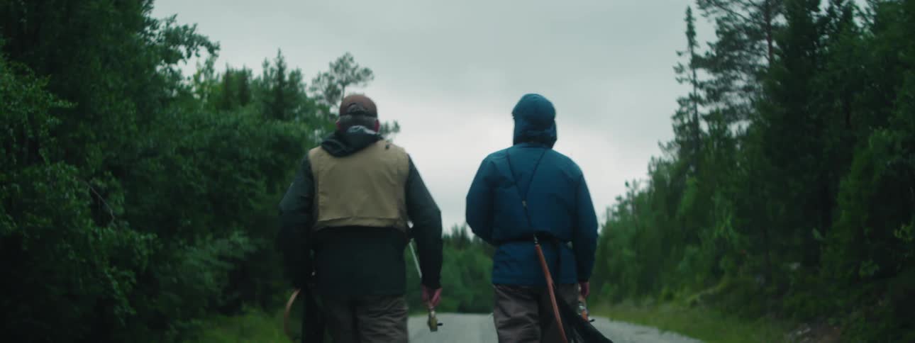 Two men walking down a trail with fishing gear