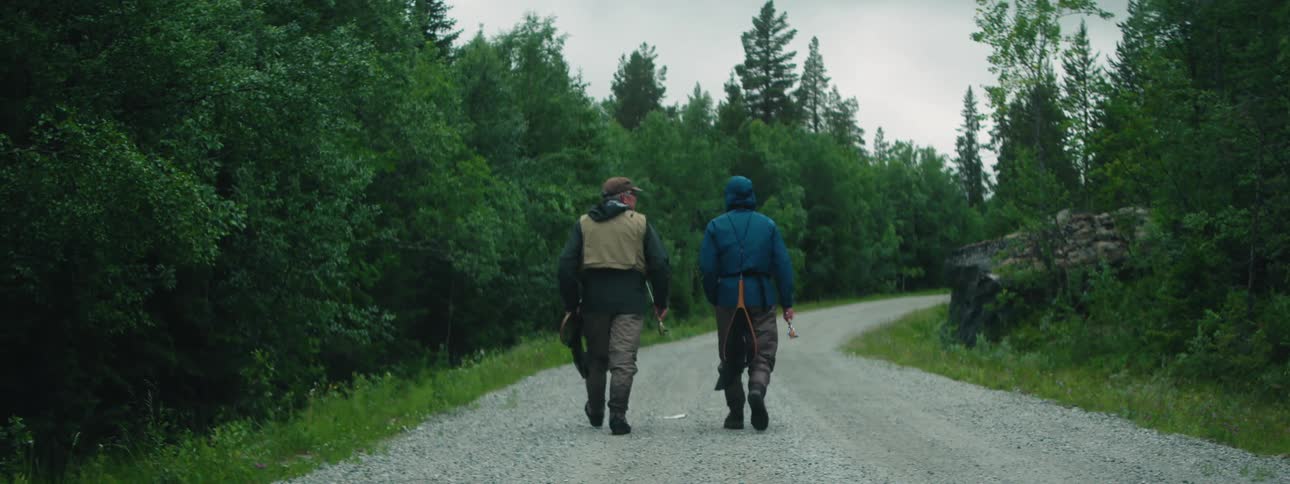 Two men walking on a trail with fishing gear