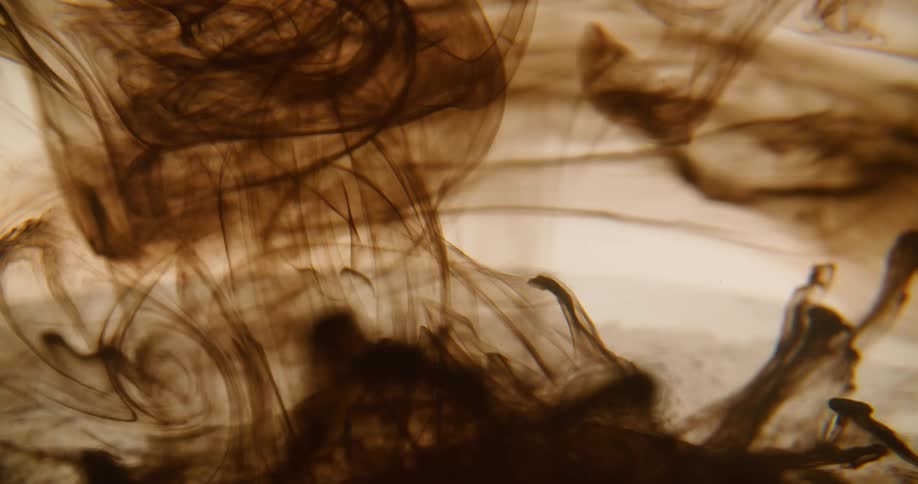 Brown dye expands and floats in rippling liquid