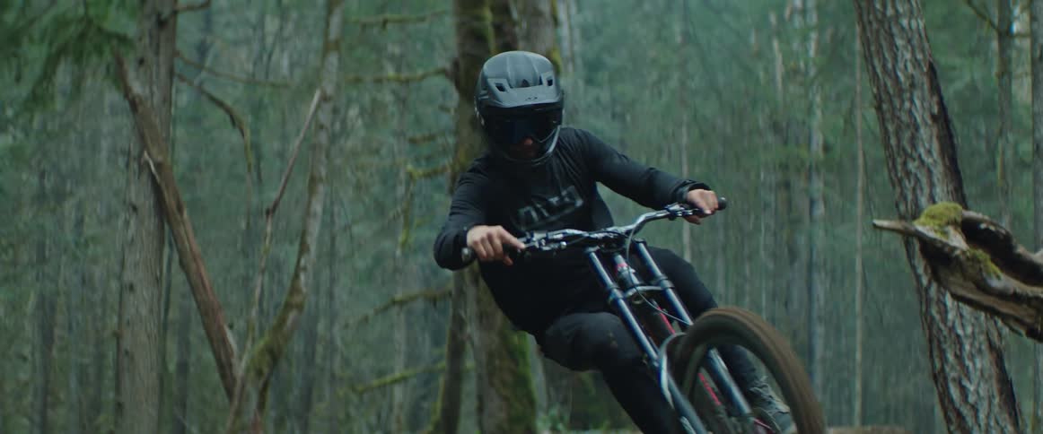 A cyclist stylishly floats through air while transferring between mountain bike trail features