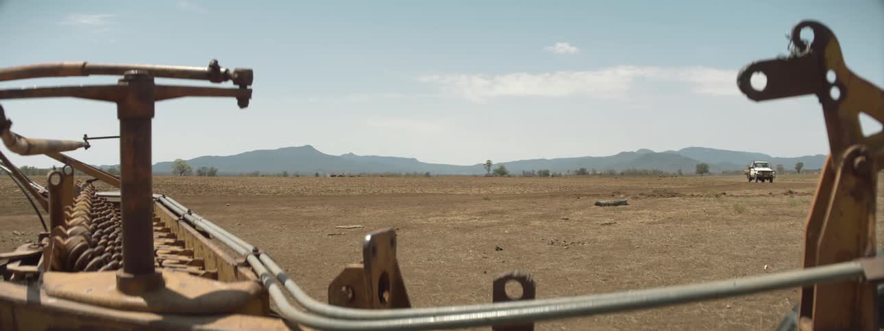 A view of a truck driving on a farm in the day