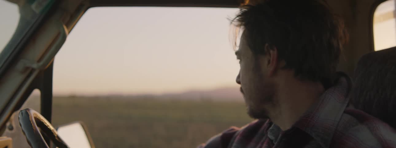 A man looks out the window as he drives a vehicle