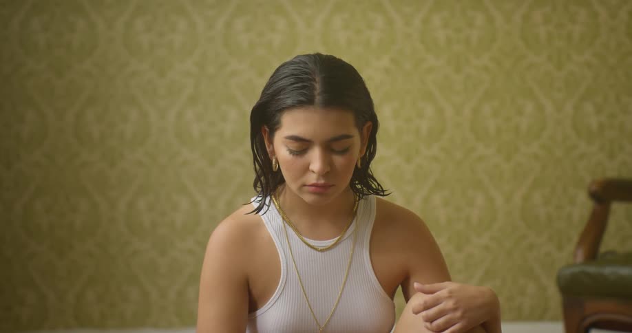 A woman is sitting in an empty room during the day