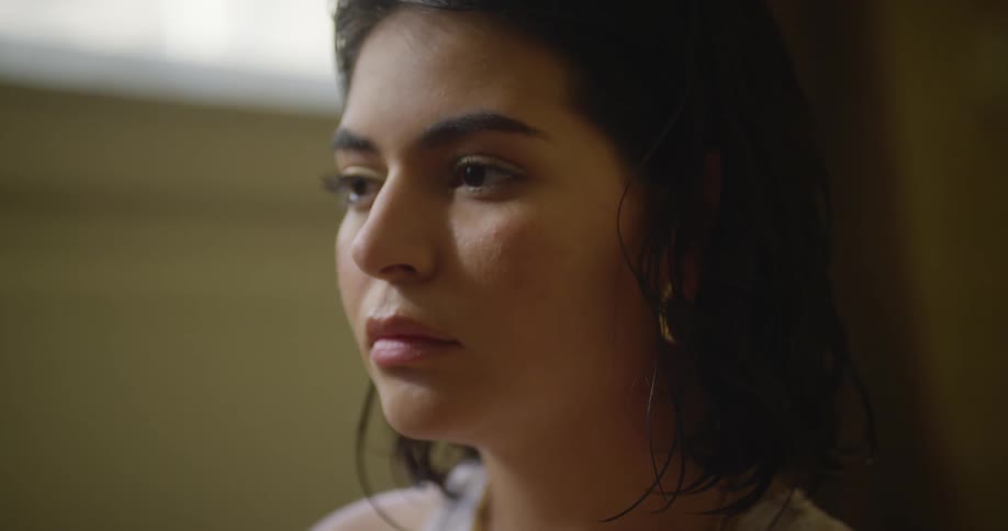 A woman sitting in a room crying looking upset