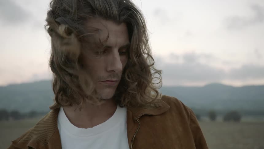 A man is looking around on a cloudy day