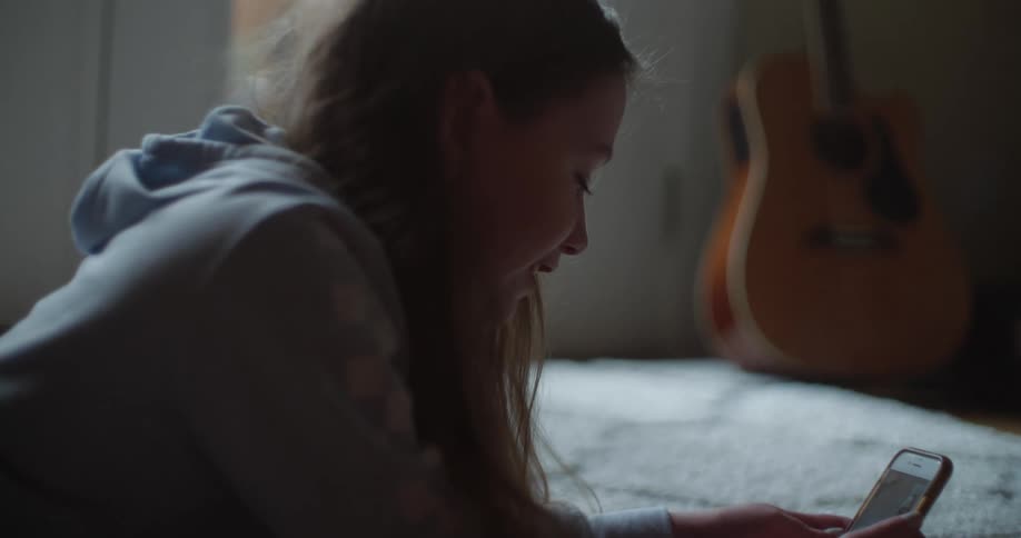 A young girl playing on a phone