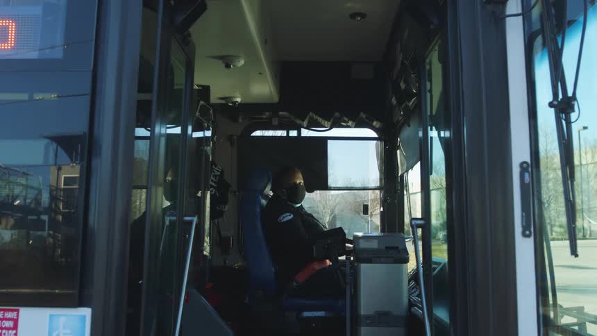 A bus driver is waiting with the door opened