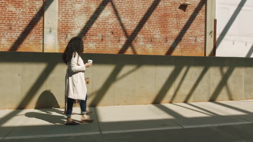 Two women walk on the sidewalk together