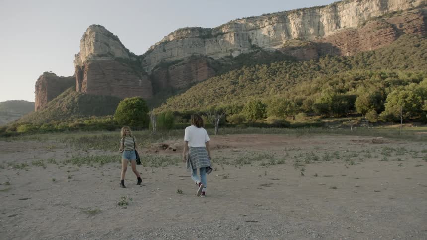 A couple throwing rocks near rocky cliffs