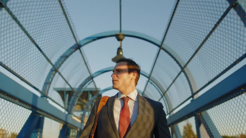 A man walking on a pedestrian bridge