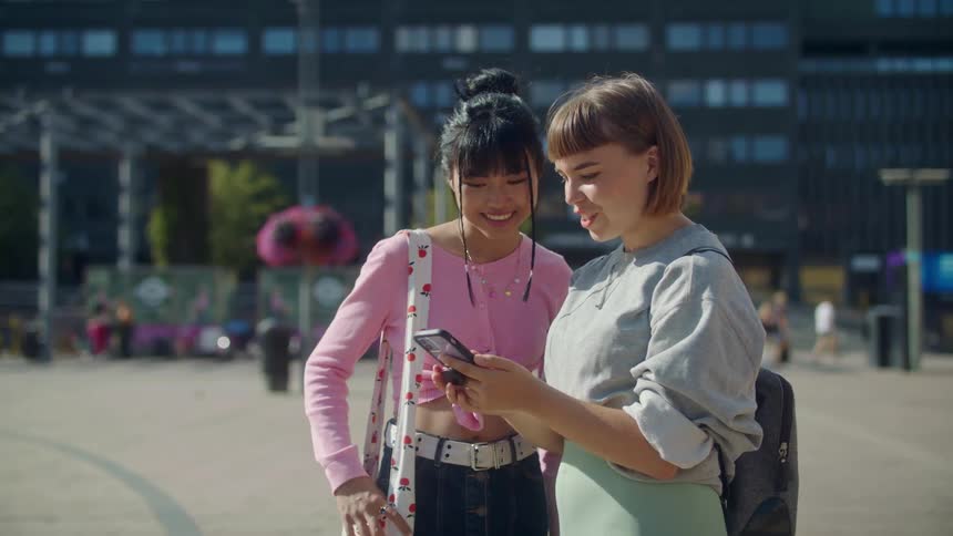 Two girls look at a cellphone together