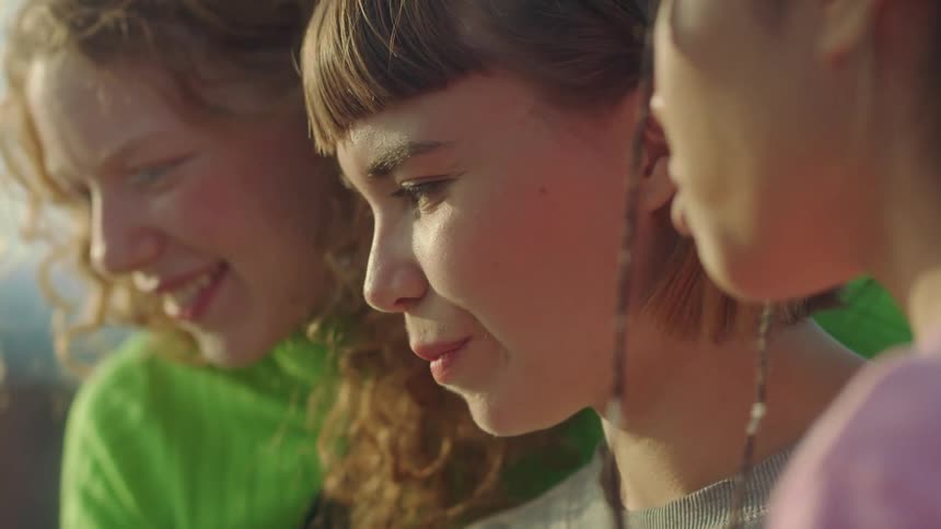 Three teenage friends laughing and talking outside