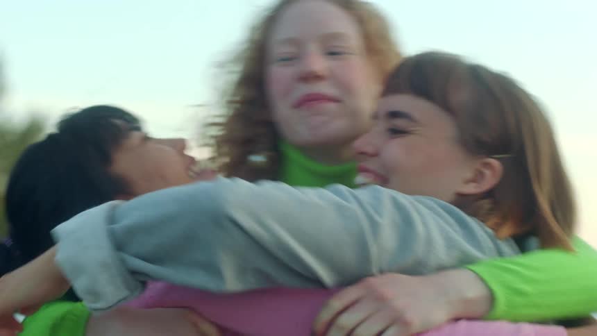 Three woman jumping and hugging each other