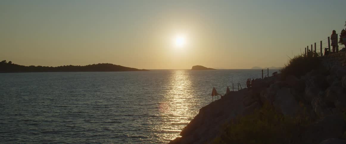The sun is setting near the shore