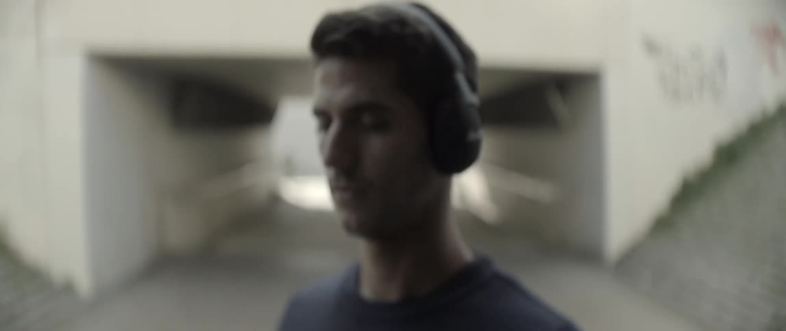 A man wearing headphones opens his eyes