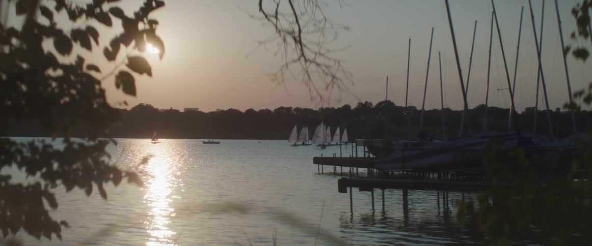 A group of sail boats travel in the water together