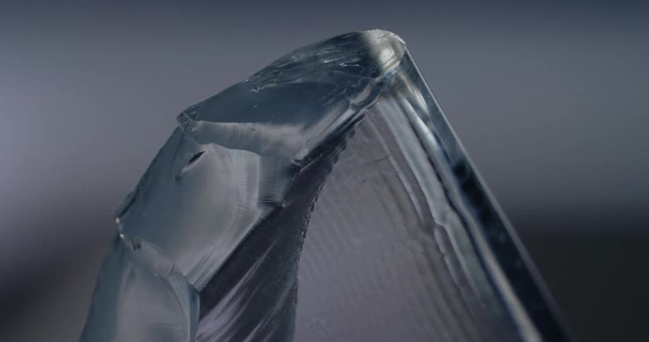 Block of clear ice in front of moving white lights