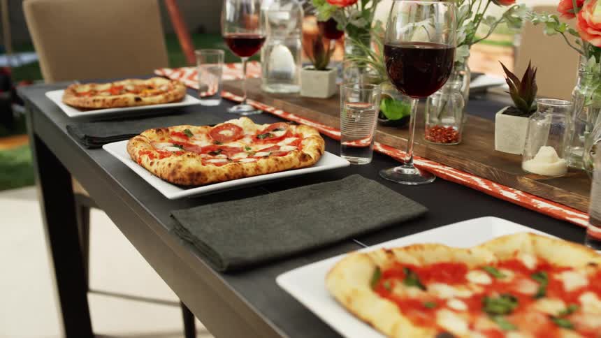 Dinner table with pizzas and drinks
