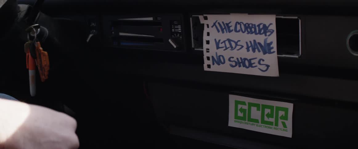 A hand pulls a shifter next to a handwritten sign