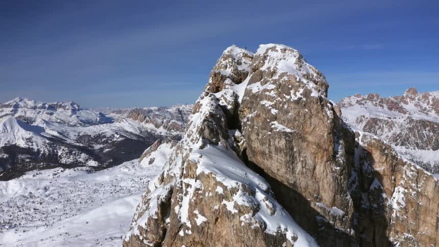 Snow covered mountain peak with a mountain range in the distance