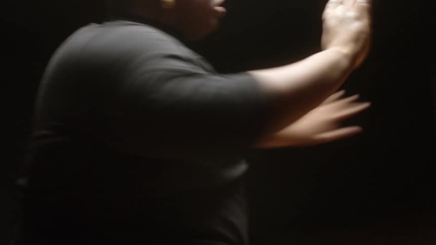 A person dancing in a dark room