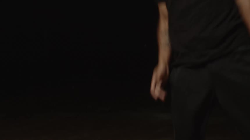 A man is breakdancing under the spotlight