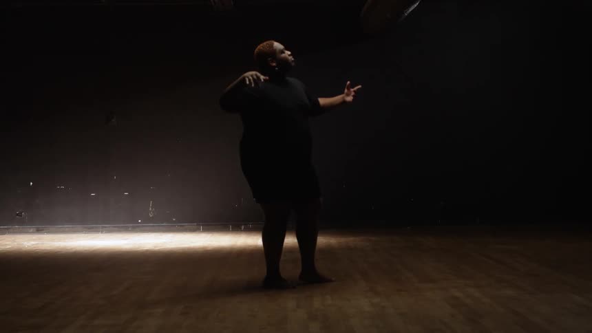 A man is performing as a spotlight flashes by