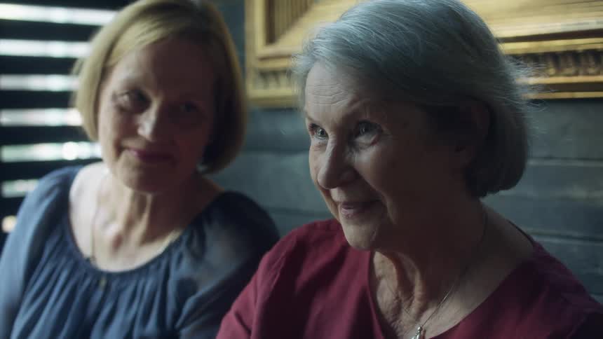 Two women talk and smile together