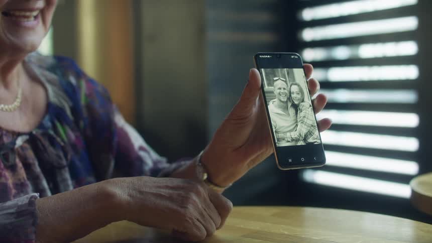 A woman shows a picture of a couple on her cellphone