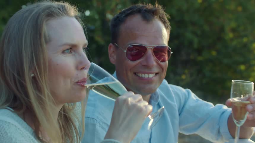 People toast drinks and talk outside