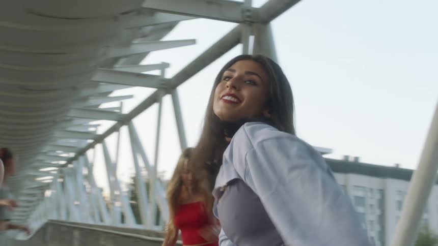 Four women are dancing on the overpass together