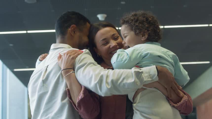 A family greets the mother as she arrives in a terminal