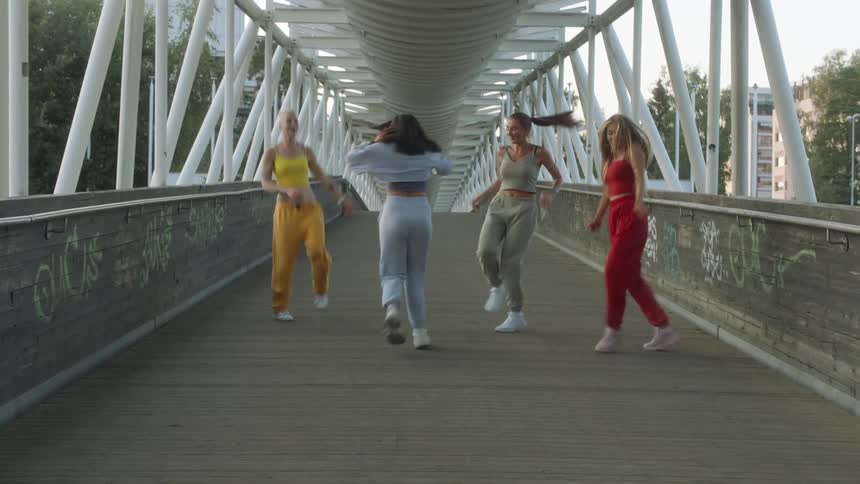 Four women are dancing together