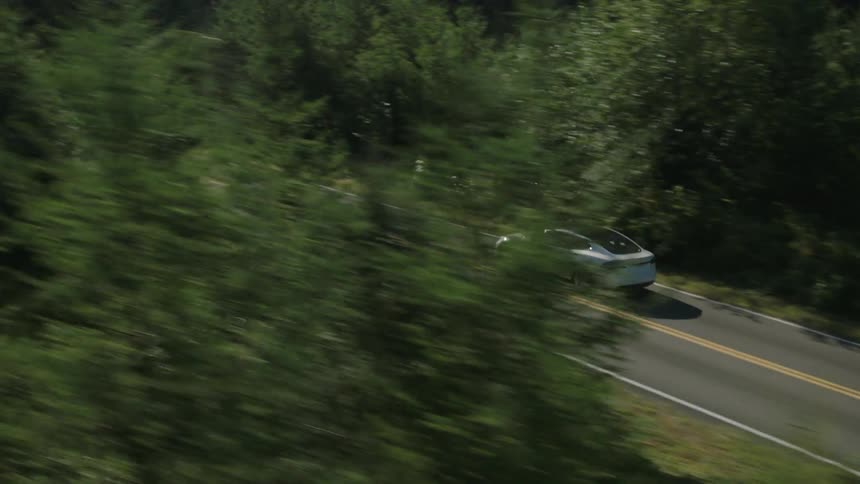 Aerial view of a car traveling down a small road