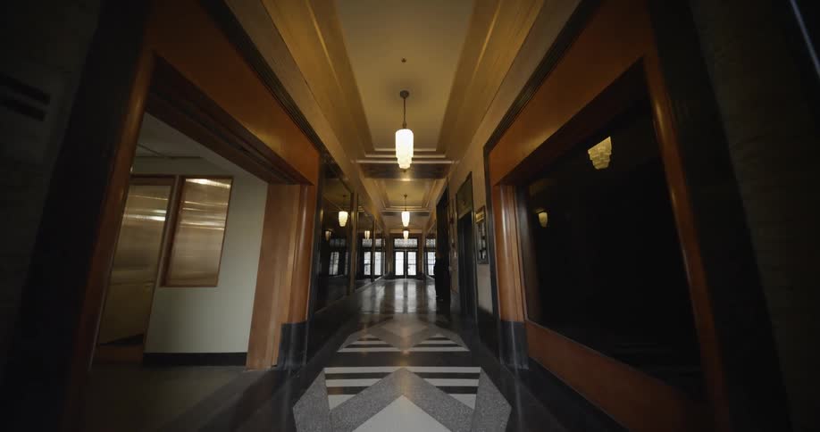 Ornate architecture and geometric patterns cover floor in wood paneled corridor