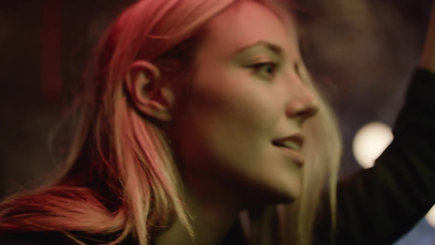 Young woman selecting music on a jukebox on a night club