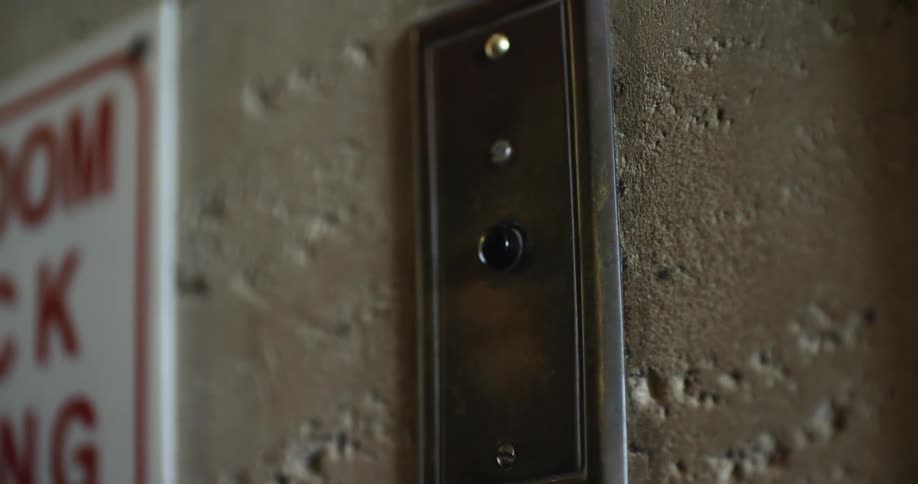 A person touching a button on the wall