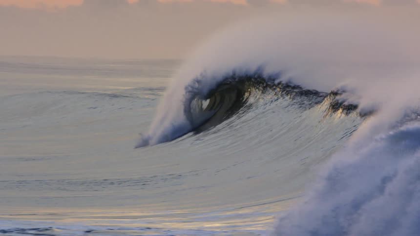 Crashing rolling ocean waves reflect sunlight