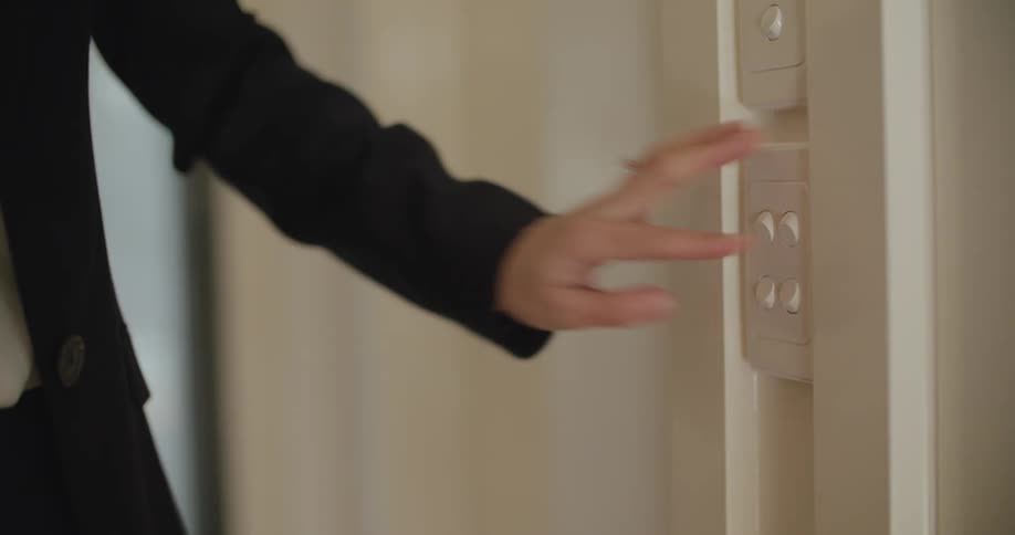 A woman turning on a light switch