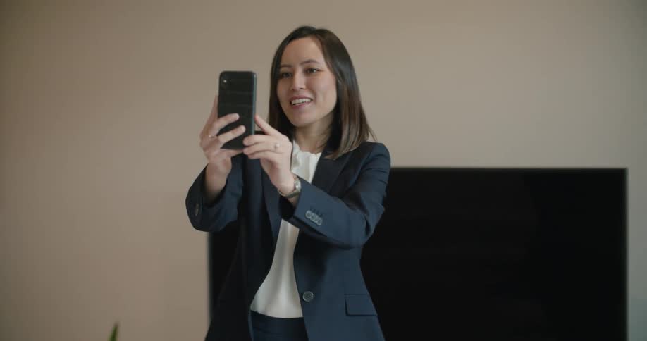 A woman moves left to right while standing in place and talking on a video call on her phone