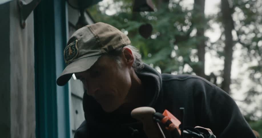 A man is working on some equipment outside a small building