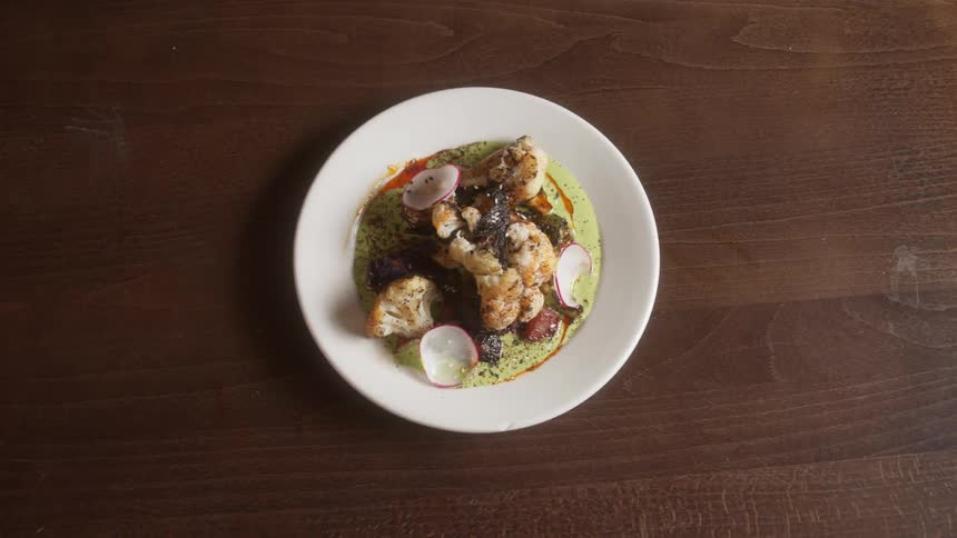 Small dish filled with seafood over a wooden table