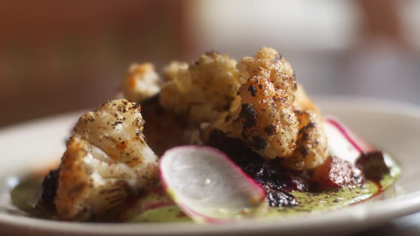 Cauliflower and an herbed sauce with garnish plated for service