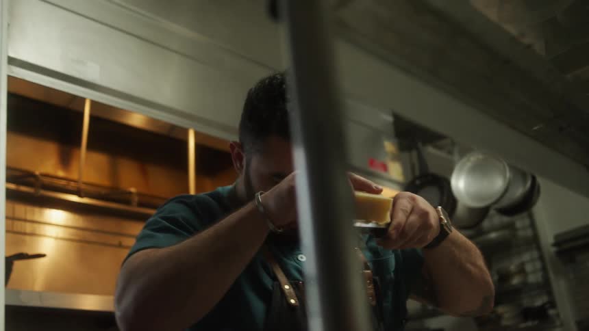 A chef is grating cheese into a bowl