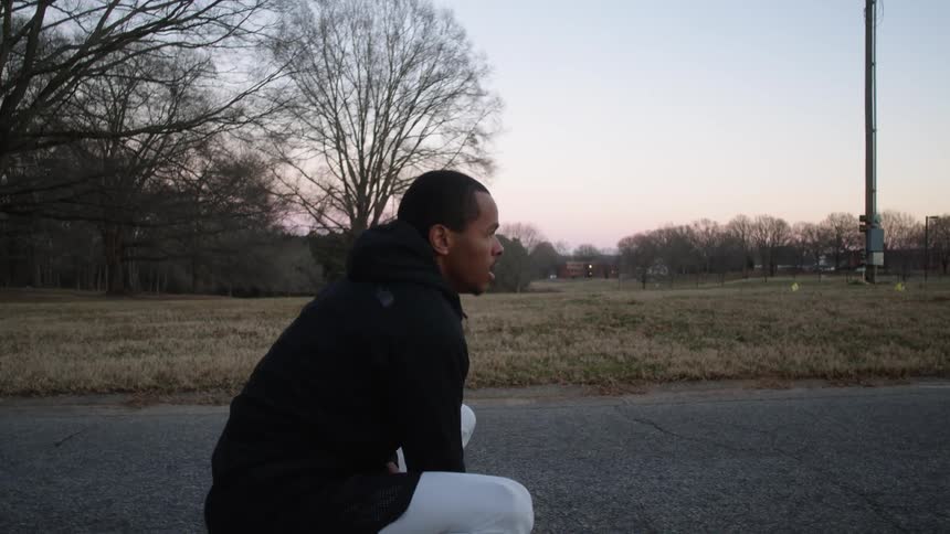 A man stops running in a park on a path