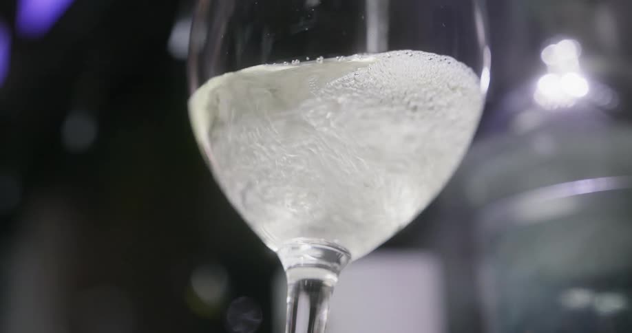 Champagne fills a glass and bubbles rise to the top