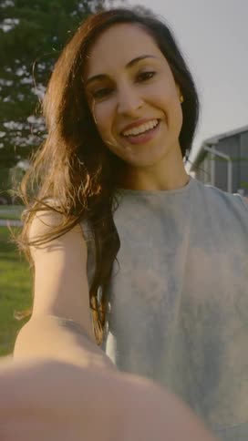 A woman records a video of herself chatting while standing outside