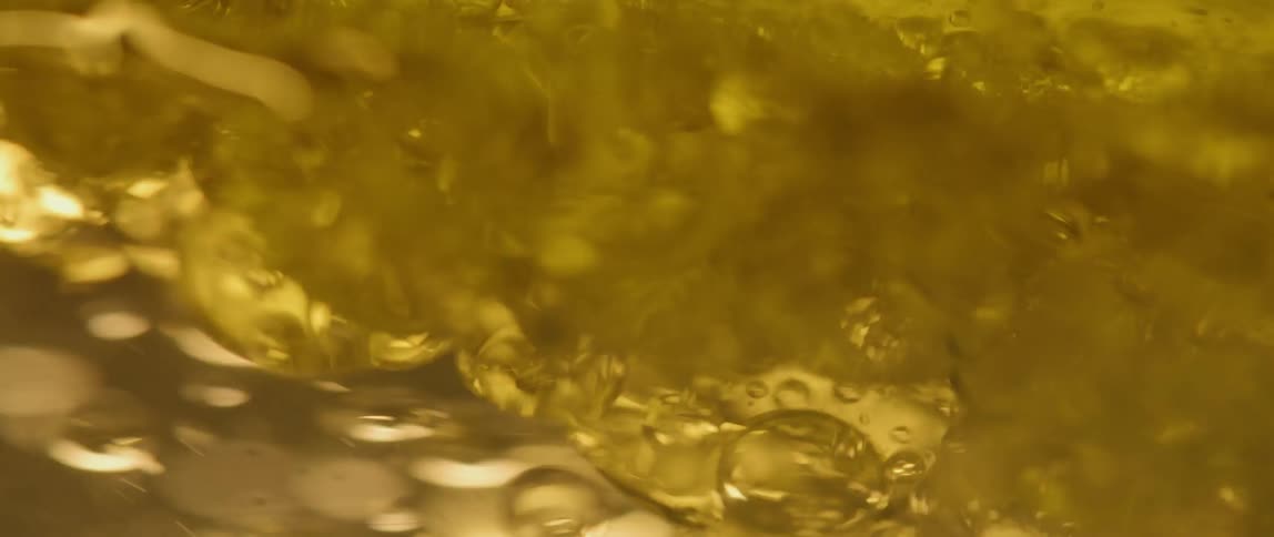 Bubbles stir in clear liquid