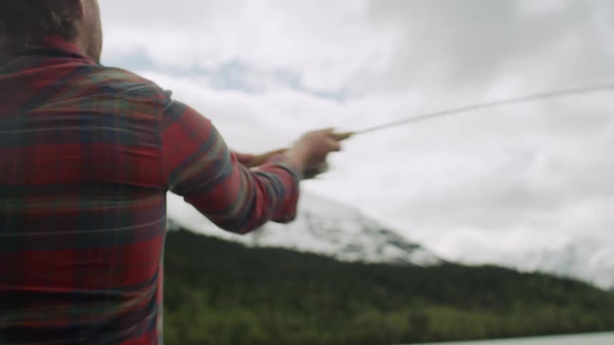 A man casting a fishing line into a lake